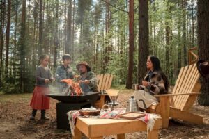 a family sat around a fire pit cooking food