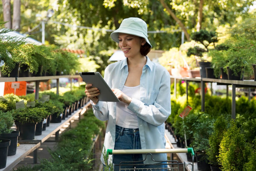garden planning apps woman using tablet in store